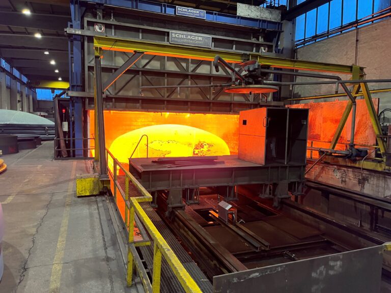 Tank head being forged via hot forming. Tank head glows with heat.